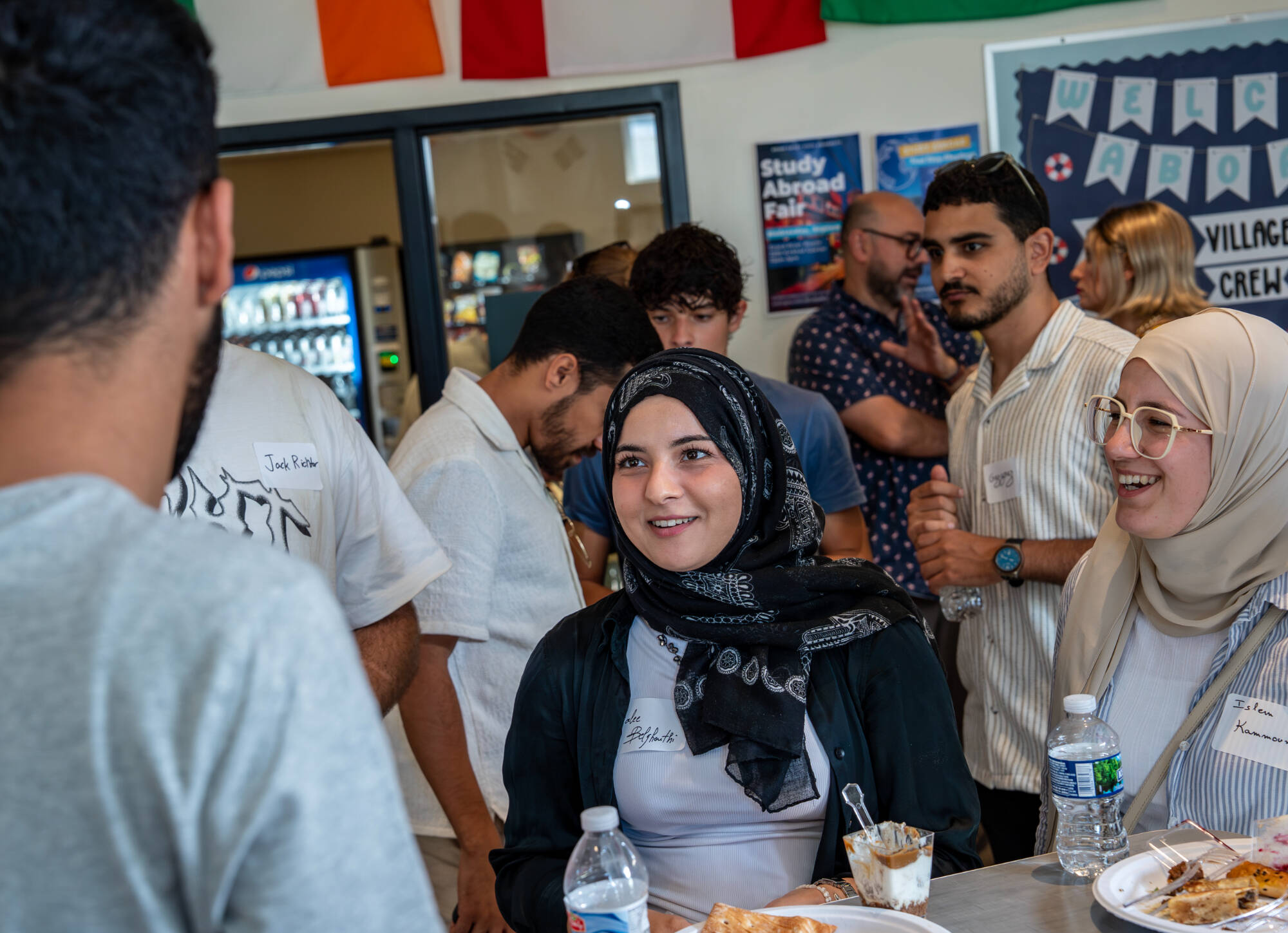Students engage in lively conversation while enjoying food during a College of Computing mixer at GVSU, highlighting community and connection in a welcoming space.